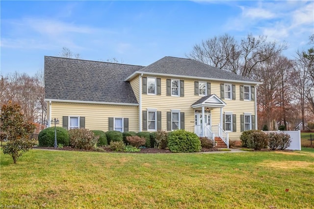 colonial-style house featuring a front yard