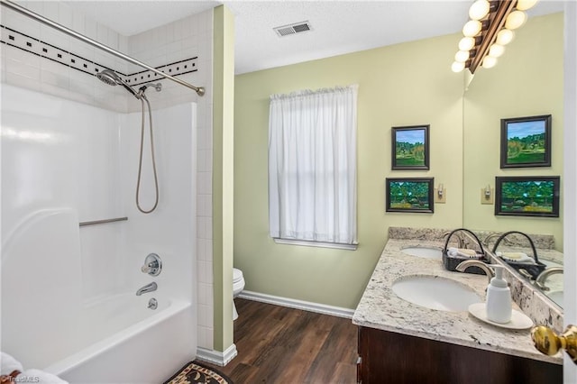 full bathroom with washtub / shower combination, hardwood / wood-style floors, vanity, and toilet