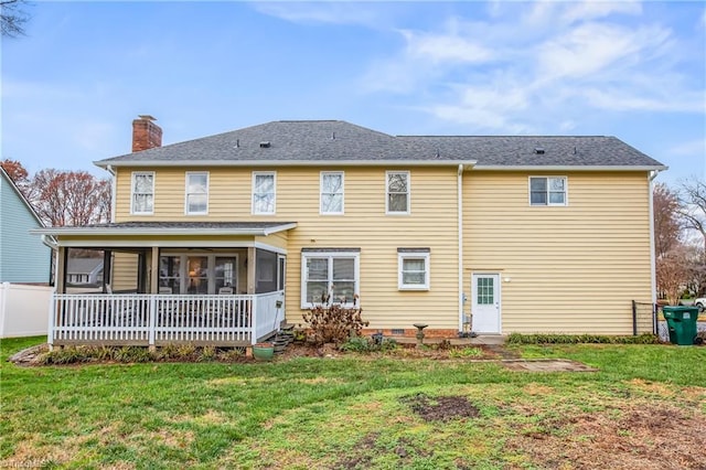 rear view of property featuring a sunroom and a yard