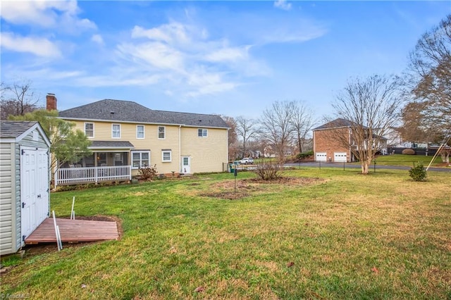 view of yard with a sunroom, a storage unit, and a deck