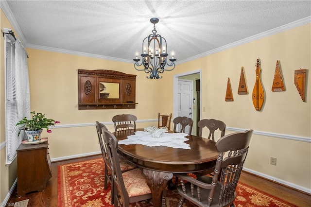 dining room featuring a textured ceiling, crown molding, dark hardwood / wood-style floors, and a notable chandelier