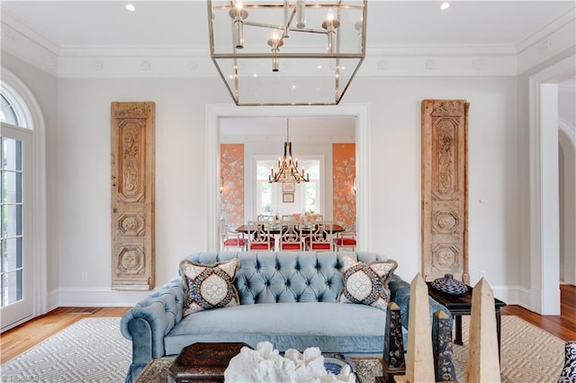 living room with ornamental molding, hardwood / wood-style floors, a healthy amount of sunlight, and a chandelier