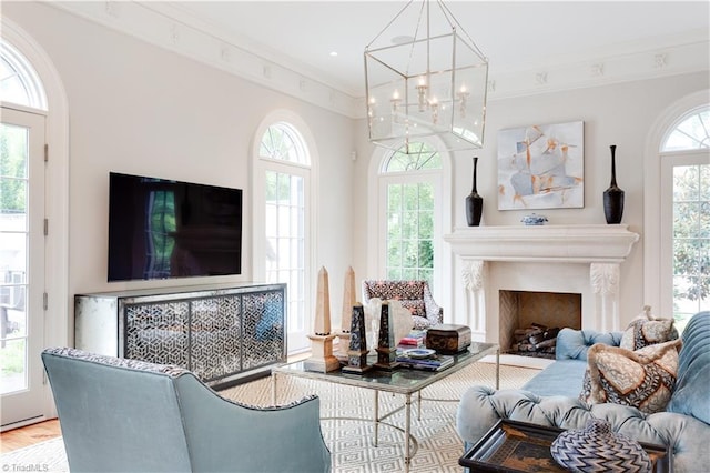 living room with crown molding, wood-type flooring, a chandelier, and plenty of natural light