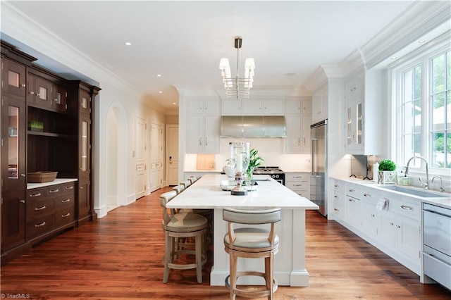 kitchen with sink, a center island, dark hardwood / wood-style flooring, stainless steel appliances, and ornamental molding