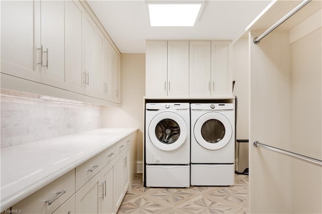 laundry area with cabinets and washing machine and clothes dryer