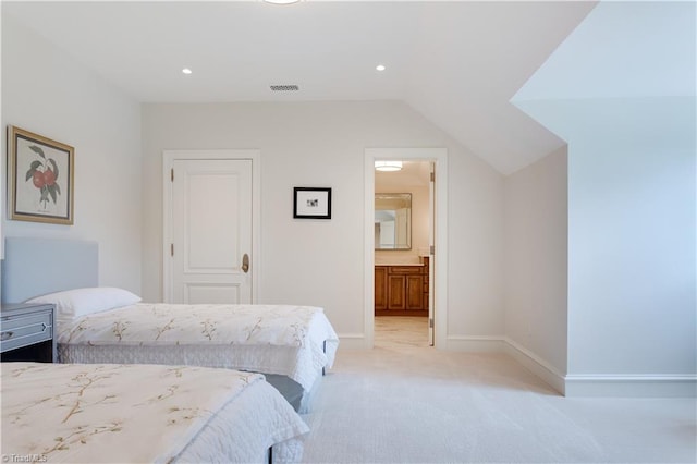 carpeted bedroom featuring ensuite bathroom and vaulted ceiling