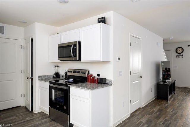 kitchen with stainless steel appliances, dark wood-type flooring, visible vents, white cabinetry, and baseboards