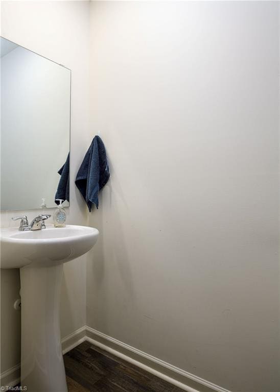 bathroom featuring a sink, wood finished floors, and baseboards