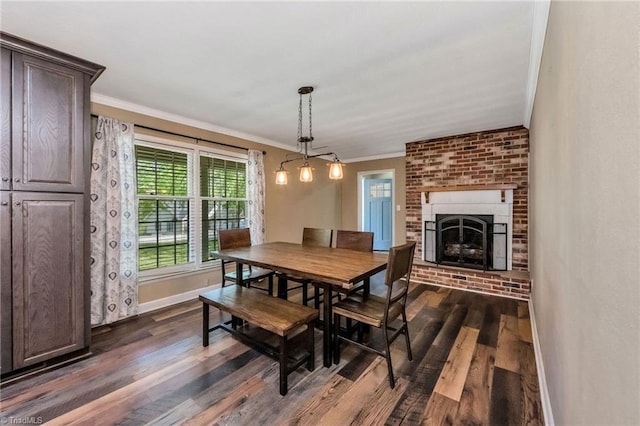 dining room with a brick fireplace, dark wood-type flooring, crown molding, and baseboards