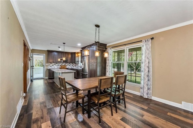 dining space with a wealth of natural light, crown molding, dark wood finished floors, and baseboards