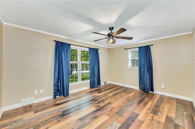 empty room featuring crown molding, visible vents, and a healthy amount of sunlight