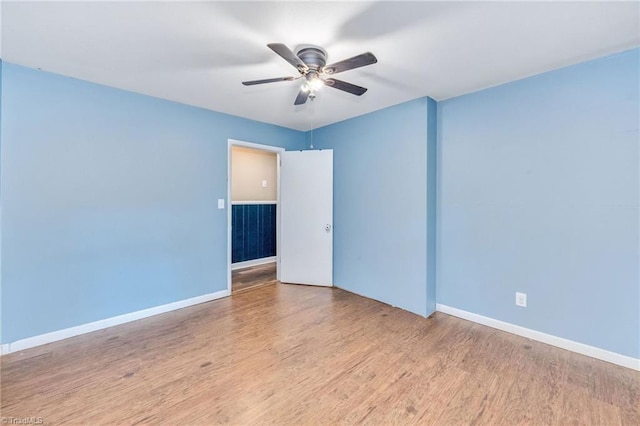 spare room with ceiling fan, wood finished floors, and baseboards