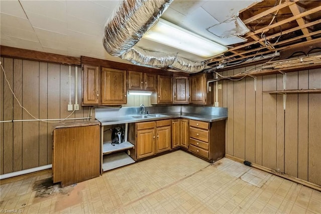 kitchen with wooden walls, a sink, open shelves, and light floors