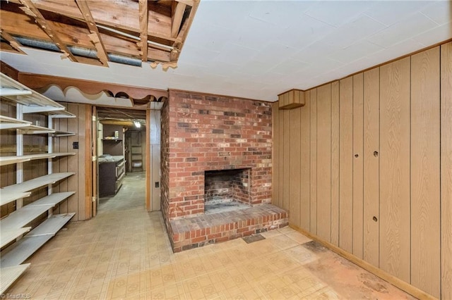 interior space with tile patterned floors, wooden walls, and a fireplace