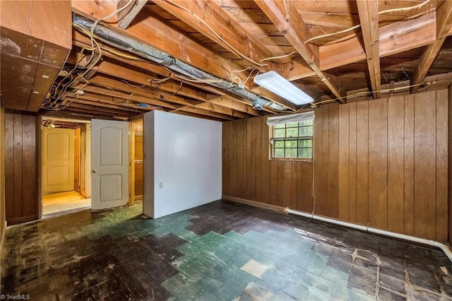 below grade area featuring tile patterned floors and wooden walls