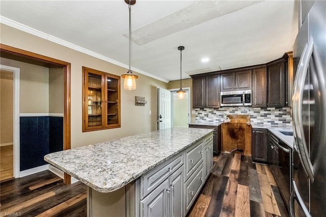 kitchen featuring decorative backsplash, appliances with stainless steel finishes, light stone countertops, ornamental molding, and dark wood finished floors