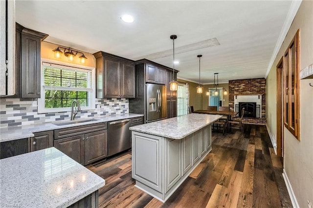 kitchen featuring dark wood-style floors, a sink, stainless steel appliances, and tasteful backsplash