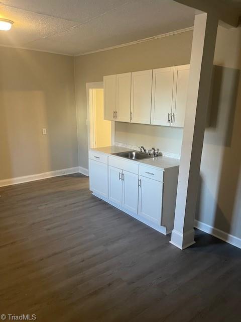 kitchen featuring white cabinetry, sink, dark wood-type flooring, and a textured ceiling