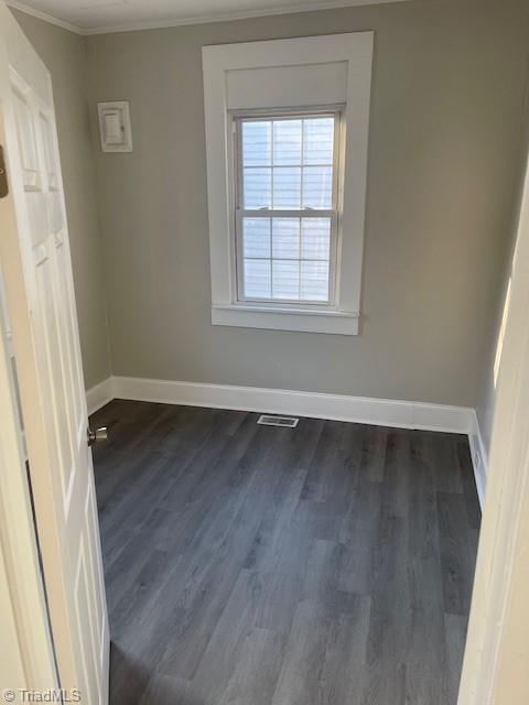 empty room with crown molding and dark hardwood / wood-style flooring