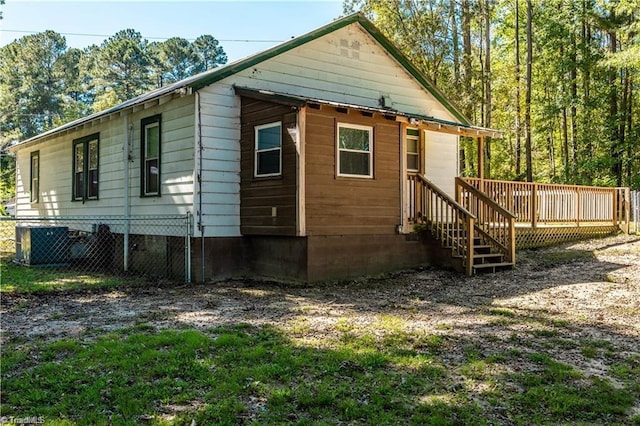 rear view of property featuring cooling unit and a deck