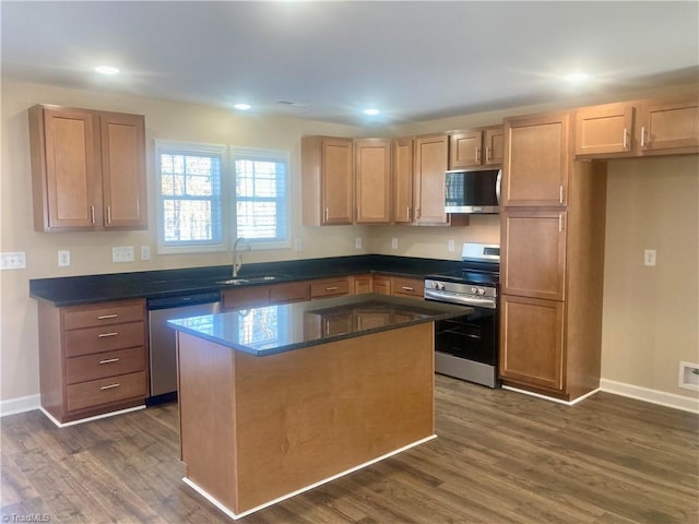 kitchen featuring a kitchen island, sink, stainless steel appliances, and dark wood-type flooring