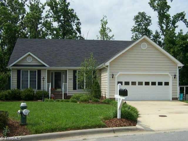 single story home featuring a garage, a front yard, and concrete driveway