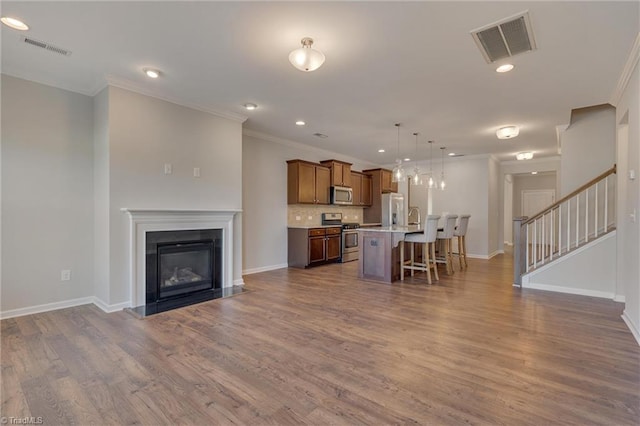 living room featuring sink, crown molding, and dark hardwood / wood-style floors