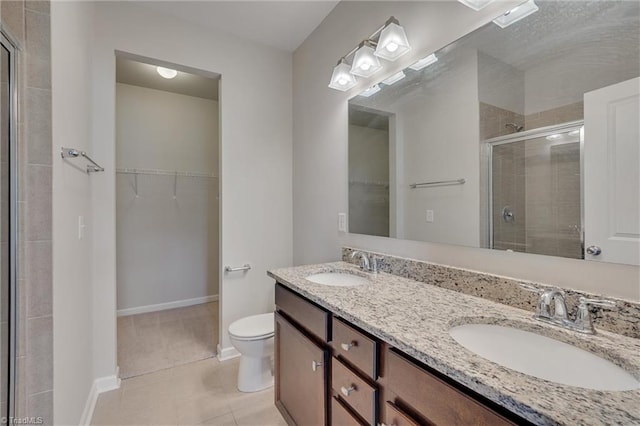 bathroom with vanity, toilet, tile patterned floors, and a shower with shower door