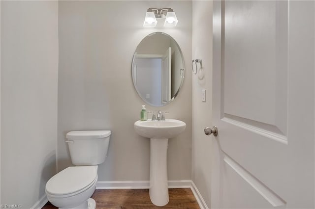 bathroom with toilet and hardwood / wood-style floors