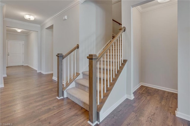 stairway featuring crown molding and wood-type flooring