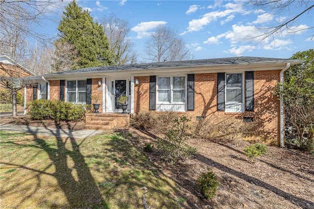 ranch-style house featuring brick siding and a front yard