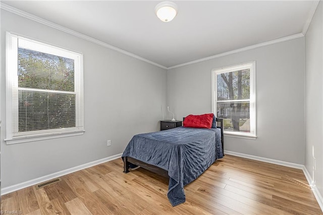 bedroom featuring multiple windows, wood finished floors, and visible vents