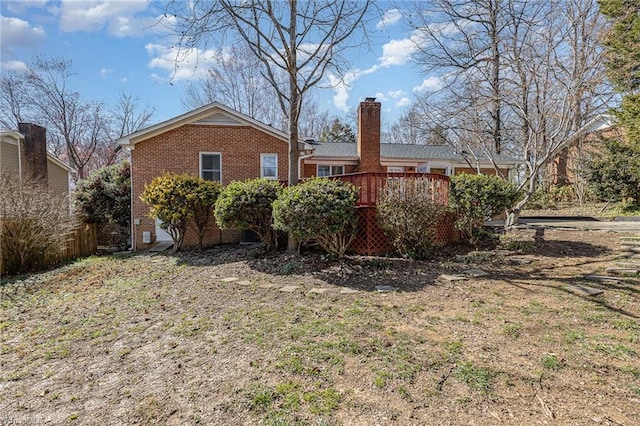 back of house with brick siding and a chimney