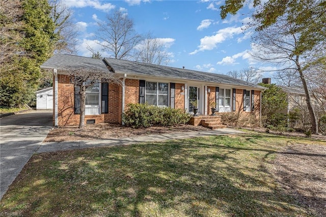 ranch-style home featuring brick siding, driveway, and a front yard