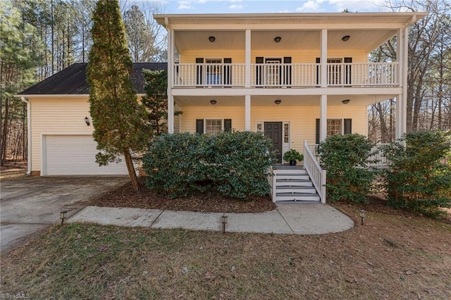 view of front of property featuring a garage, a balcony, and covered porch