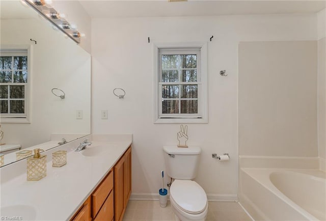 bathroom with tile patterned floors, vanity, toilet, and a bathing tub