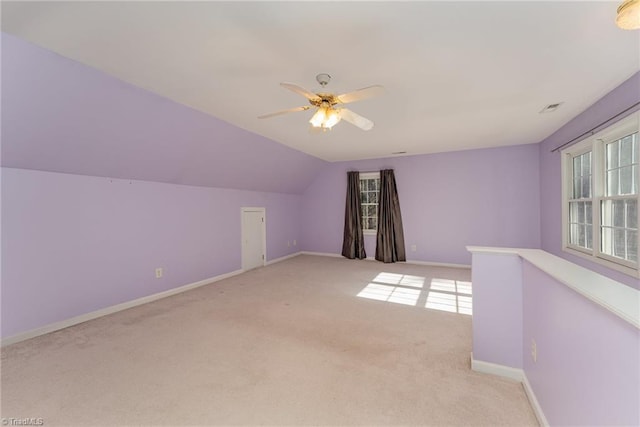 additional living space with light carpet, vaulted ceiling, and ceiling fan