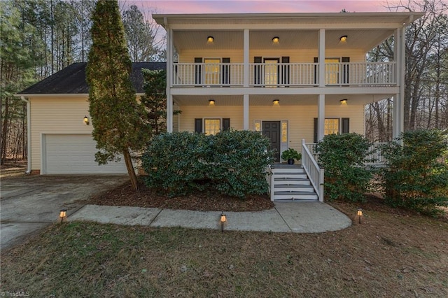 view of front of property with a garage, a balcony, and covered porch