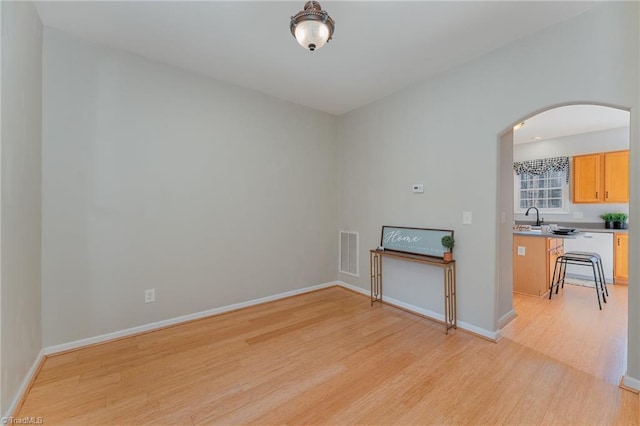 unfurnished living room with sink and light hardwood / wood-style flooring