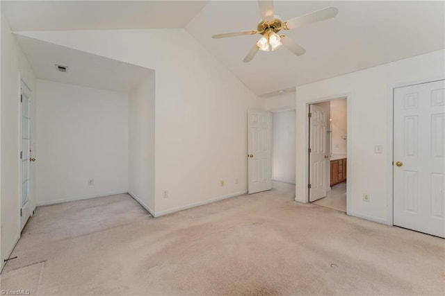 unfurnished bedroom with vaulted ceiling, light colored carpet, and ensuite bathroom