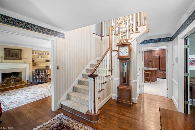 staircase with built in shelves, wood-type flooring, and ornamental molding