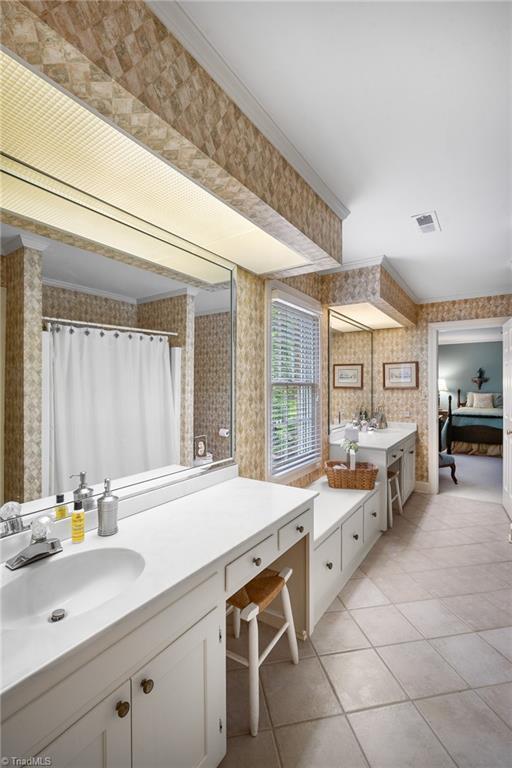 bathroom featuring tile patterned flooring, vanity, and ornamental molding