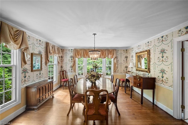 dining space with a chandelier, wood-type flooring, plenty of natural light, and crown molding