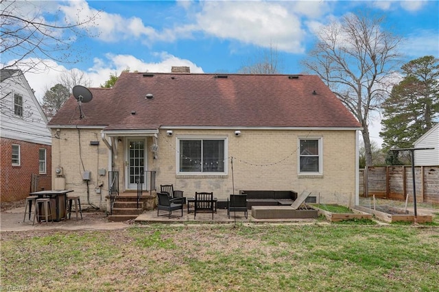 rear view of house featuring an outdoor hangout area, brick siding, a vegetable garden, and a patio area