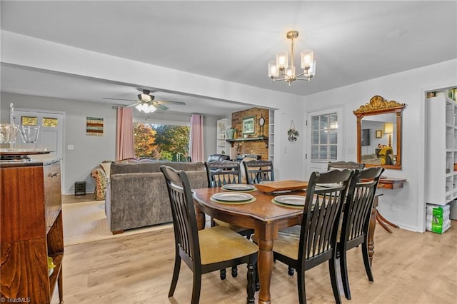 dining room featuring light hardwood / wood-style flooring and ceiling fan with notable chandelier