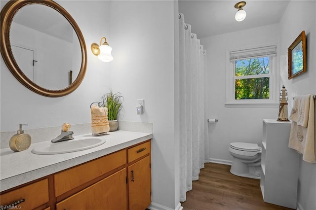 bathroom with vanity, toilet, and hardwood / wood-style flooring