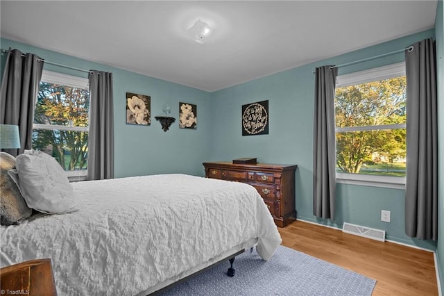 bedroom featuring light hardwood / wood-style flooring and multiple windows