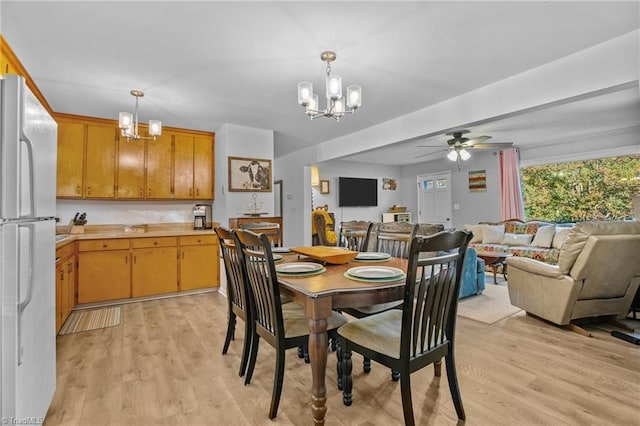 dining area featuring ceiling fan with notable chandelier and light wood-type flooring