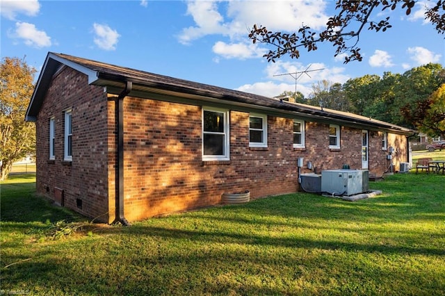 view of property exterior with a lawn and central AC unit