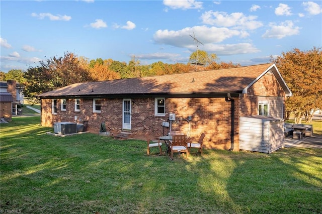 back of house featuring central air condition unit and a yard